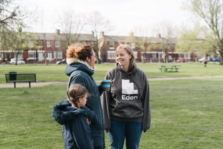Eden team member talking to a woman and child