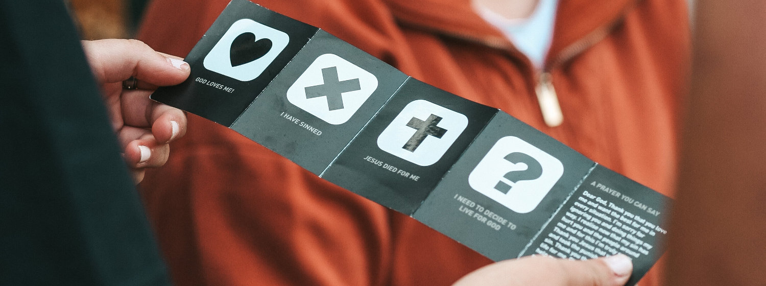 Person holding a leaflet showing the four points