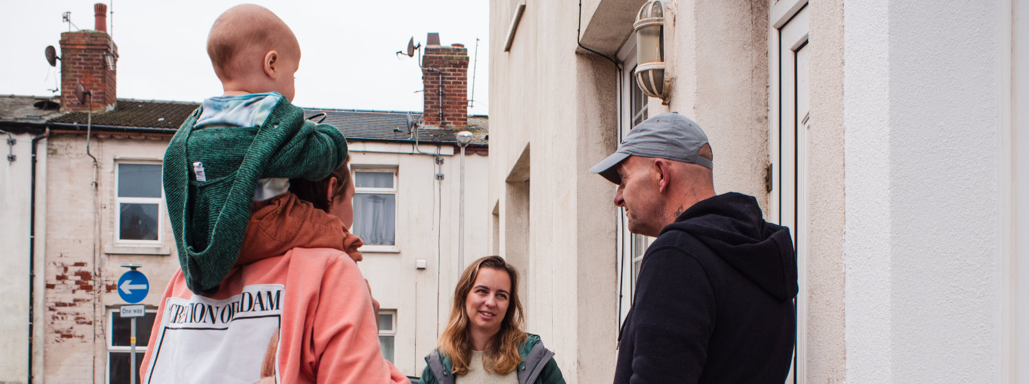 Group of people chatting by terraced housing