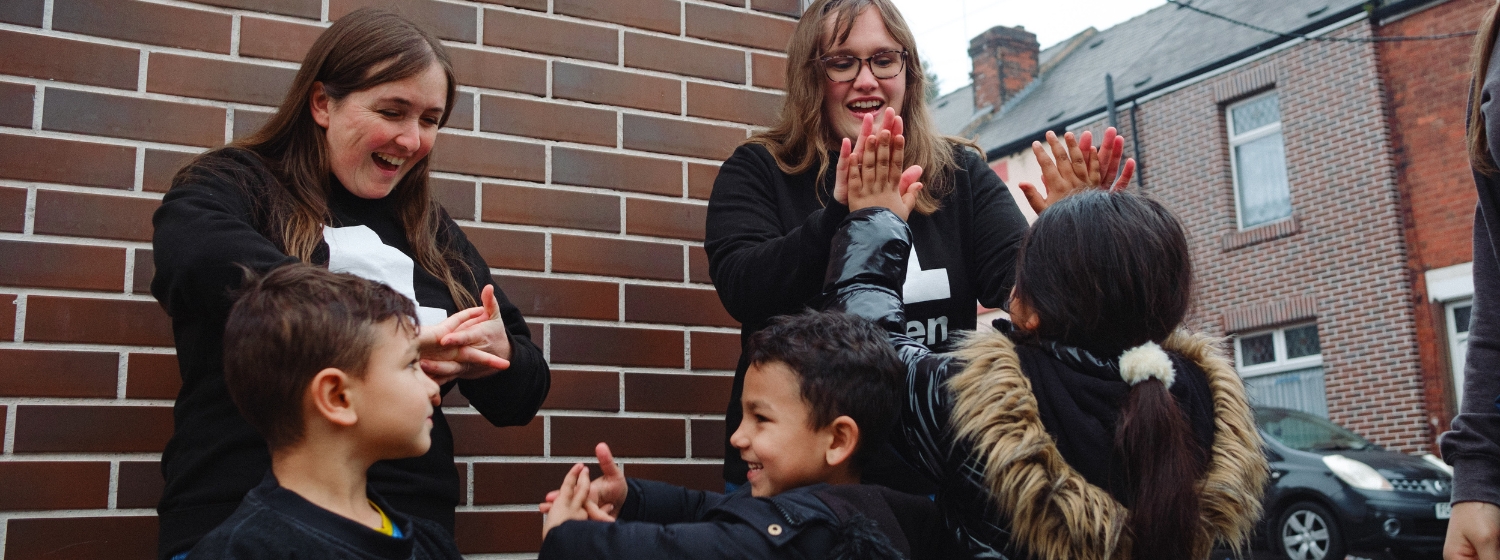 Eden team members playing on the street with young children