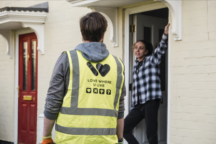 A Love Where U Live team member chats on a doorstep
