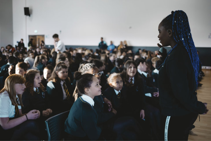 Mission team member talking to schoolchildren in an assembly