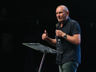 Andy Hawthorne teaching from stage.