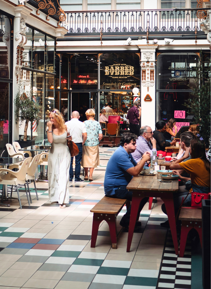 People eat outside a cafe in Barton Arcade.