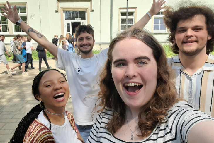 Four students take a selfie outside an international schools mission project.