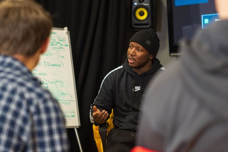 A Message team member coaches some young people in a music studio.
